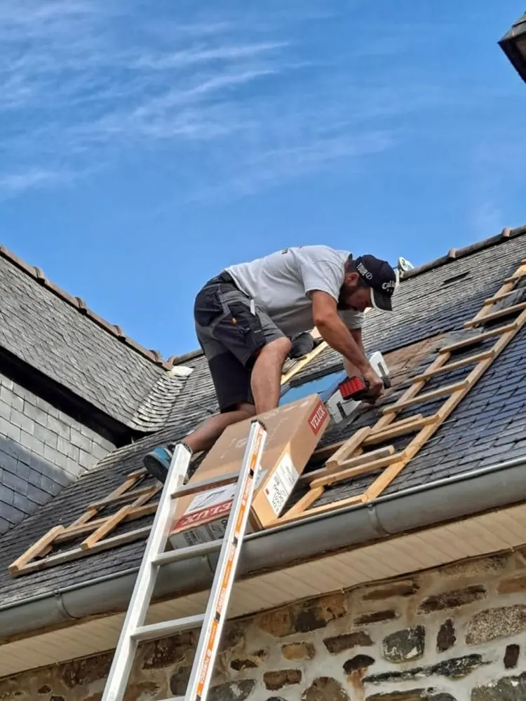 Couvreur au travail sur une toiture en ardoise
