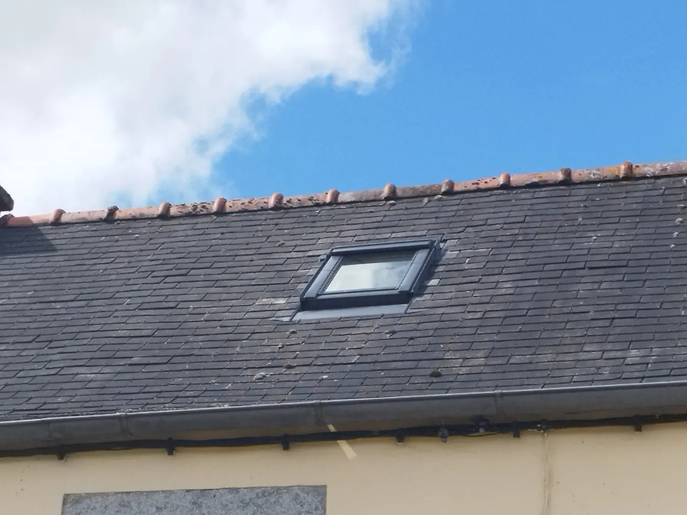 Fenêtre de toit posée dans une couverture en ardoise